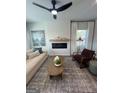 Well-lit living room boasts a modern ceiling fan, fireplace with wooden mantel, and elegant furnishings at 11523 Kimberly Way # 6, Hampton, GA 30228