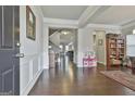 Spacious living room features hardwood floors, wainscoting, and views into the kitchen at 130 Brooks Cir, Hampton, GA 30228