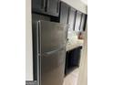 Kitchen with stainless steel refrigerator, dark cabinets, and granite countertops at 4477 Golf Vista Cir, Decatur, GA 30035