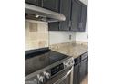 Close-up of a kitchen featuring stainless steel appliances, dark cabinets, and granite countertops at 4477 Golf Vista Cir, Decatur, GA 30035