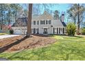 Traditional two-story home featuring a manicured lawn, two-car garage, and charming facade with black shutters at 339 Kensington Dr, Peachtree City, GA 30269