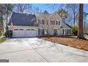 Traditional two-story home featuring a manicured lawn, two-car garage, and charming facade with black shutters at 339 Kensington Dr, Peachtree City, GA 30269