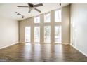 Bright living room with vaulted ceilings, large windows, modern lighting, and wood-look floors at 6290 Shallowford Way, Douglasville, GA 30135