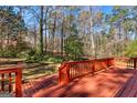 A spacious wooden deck overlooks a lush, tree-filled backyard at 9491 Hidden Branch Dr, Jonesboro, GA 30236