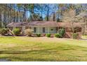 Charming one-story home with a well-maintained front lawn, mature trees, and covered porch at 9491 Hidden Branch Dr, Jonesboro, GA 30236