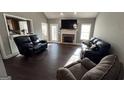 Spacious living room with dark floors, a brick fireplace, and comfortable leather seating at 946 Creek Run Pl, Temple, GA 30179