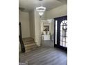 Bright foyer boasting updated lighting, a large mirror, and wood-look stairs at 7193 Cavender Sw Dr, South Fulton, GA 30331