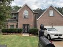 Beautiful brick home with a manicured lawn, decorative shrubbery, and a welcoming front entrance at 7193 Cavender Sw Dr, South Fulton, GA 30331