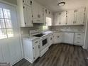 Bright kitchen features white cabinets, marble countertops, new appliances and a door to the outside at 3953 Woodland Se Cir, Conyers, GA 30013