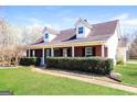 Inviting home featuring manicured front lawn and classic brick facade at 136 Leguin Forest Dr, Locust Grove, GA 30248