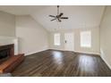 Bright living room with vaulted ceiling, fireplace, and wood-look floors at 136 Leguin Forest Dr, Locust Grove, GA 30248