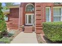 Elegant front entrance with brick steps, decorative planters, and arched window at 643 Old Greenville Rd, Fayetteville, GA 30215