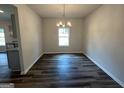 Dining area features hardwood floors, a modern chandelier, and large window for natural light at 1102 Campbell Rd # 01, Covington, GA 30014