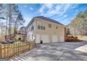 Multi-car garage and wooden deck overlooking backyard surrounded by a wood privacy fence at 140 Rockglen Ct, Fayetteville, GA 30215