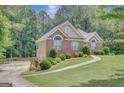 Well-kept exterior with brick accents, complemented by a lush green lawn and mature trees at 140 Rockglen Ct, Fayetteville, GA 30215