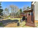 Private backyard featuring a large deck, lush lawn, and mature trees, perfect for entertaining at 149 Crown Glen Way, Stockbridge, GA 30281