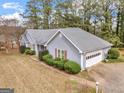 Charming single-story home with gray siding, manicured bushes, and an attached two-car garage at 230 Acorn Ct, Mcdonough, GA 30253
