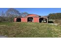 Functional red barn with open bays for equipment storage and workspace, set in a spacious yard at 1761 Reavesville Rd, Bowdon, GA 30108