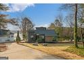View of the home, situated near a lake and featuring modern architecture with lovely landscaping at 1190 Plantation Dr, Villa Rica, GA 30180