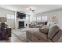 Comfortable living room showcasing a fireplace, large television, cozy sectional, and bright windows with plantation shutters at 6910 Newcastle Ct, Fairburn, GA 30213