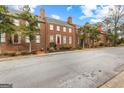Street view showcasing the red brick townhouses with manicured front yards and mature trees at 180 Habersham Pl, Fayetteville, GA 30214