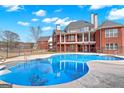 Large inground pool with multi-level brick home in background, all surrounded by a wrought iron fence at 560 Birkdale Dr, Fayetteville, GA 30215