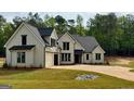 Stylish modern farmhouse featuring a manicured lawn, 3-car garage, and charming curb appeal at 545 Discovery Lake Dr # 409, Fayetteville, GA 30215