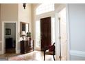 Inviting foyer with high ceilings, tile floor, and dark wood door with decorative glass panes at 5188 Ashley Se Dr, Covington, GA 30014