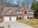 Beautiful two-story brick home with two-car garage, gray shingle roof and a well-manicured lawn at 204 Eleanor Ct, Stockbridge, GA 30281