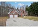 Stunning two-story red brick home with a large driveway, attached garage and manicured front lawn at 204 Eleanor Ct, Stockbridge, GA 30281