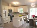 Well-lit kitchen boasts white cabinets, stainless steel appliances, an island with bar seating, and stylish backsplash at 5017 Galbraith Cir, Stone Mountain, GA 30088