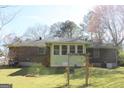 Exterior shot of a brick home with a spacious backyard featuring a garden at 6064 Monica Dr, Morrow, GA 30260