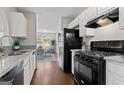 Efficient kitchen design with white cabinets and black appliances at 217 Crystal Ct, Hampton, GA 30228