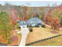 An aerial view of the property shows mature trees, a well-manicured lawn and a quaint black rail fence at 1080 Gaithers Rd, Mansfield, GA 30055