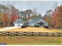 Charming home with a sprawling lawn, tasteful landscaping and a picturesque black rail fence at 1080 Gaithers Rd, Mansfield, GA 30055
