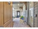 Welcoming covered porch with brick flooring, comfortable seating, and a glimpse of the elegant front door at 1110 Blair Ln, Peachtree City, GA 30269
