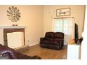 Cozy living room with a brick fireplace and mantle plus wood style flooring at 142 Kylee Ct, Villa Rica, GA 30180