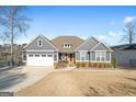 Attractive gray home with a well-manicured lawn and an attached garage near a lake at 1278 Heritage Dr, Villa Rica, GA 30180