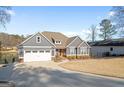 Gray home with an attached garage, stone accents, and a well-manicured lawn near a lake at 1278 Heritage Dr, Villa Rica, GA 30180