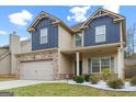 Inviting two-story home with brick accents, a two-car garage, and neat landscaping at 312 Maddi Grace Ct, Locust Grove, GA 30248