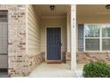 Inviting front door with sidelight, brick accents, and well-maintained landscaping at 312 Maddi Grace Ct, Locust Grove, GA 30248