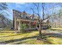 Exterior view revealing the side elevation, screened porch, and surrounding greenery at 897 Winding Trl, Lawrenceville, GA 30046