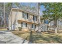 Charming split-level home with a long driveway, nestled amongst trees in a serene setting at 4605 Woodcroft Cv, Snellville, GA 30039