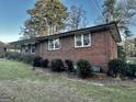 Brick house with trimmed bushes along the side, complemented by shuttered windows and a well-manicured lawn at 398 Lockridge Ln, Lawrenceville, GA 30046