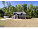 Spacious two-story home with a well-manicured front lawn and a long driveway leading to a shed at 830 Turner Rd, Mcdonough, GA 30252