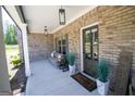 Charming covered front porch with brick columns, comfortable seating, and decorative plants at 830 Turner Rd, Mcdonough, GA 30252