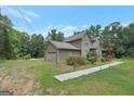 Charming two-story home featuring a stone chimney, side entry garage and lush landscaping at 133 Harold Dr, Mcdonough, GA 30253