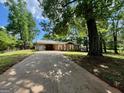 Single story home with mature trees and a long driveway leading up to the residence at 360 Meadowbrook Dr, Mcdonough, GA 30253