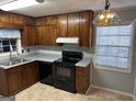 The kitchen features wooden cabinets, laminate countertops, and black appliances at 360 Meadowbrook Dr, Mcdonough, GA 30253