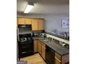 A functional kitchen with light wood cabinets and black appliances at 45 Fieldview Ln, Covington, GA 30016